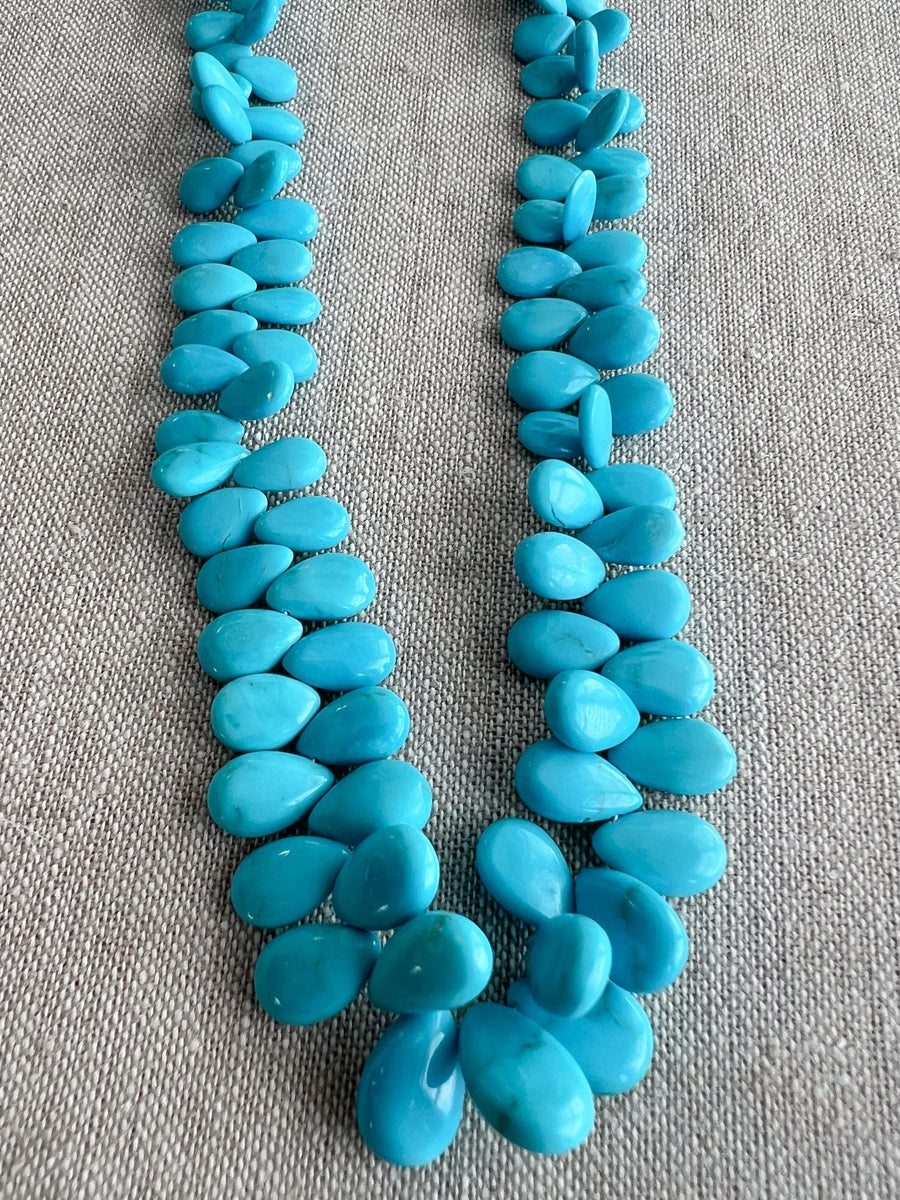 Smooth almond-shaped Sleeping Beauty turquoise beads showing natural Arizona turquoise color and polished surfaces. detail shot