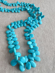 Smooth almond-shaped Sleeping Beauty turquoise beads showing natural Arizona turquoise color and polished surfaces.