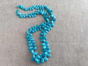 Smooth almond-shaped Sleeping Beauty turquoise beads showing natural Arizona turquoise color and polished surfaces.