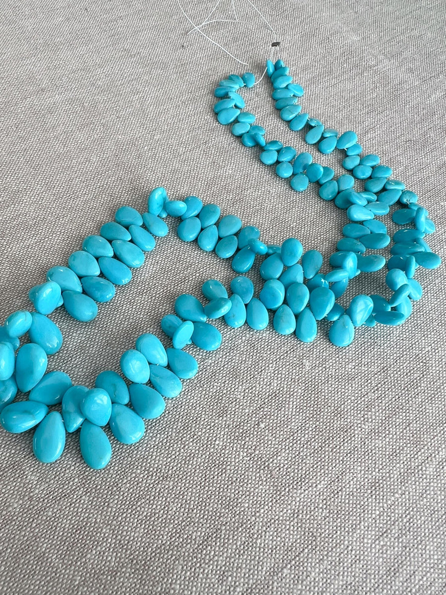 Smooth almond-shaped Sleeping Beauty turquoise beads showing natural Arizona turquoise color and polished surfaces.