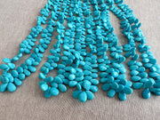 Smooth almond-shaped Sleeping Beauty turquoise beads showing natural Arizona turquoise color and polished surfaces. multiple strands