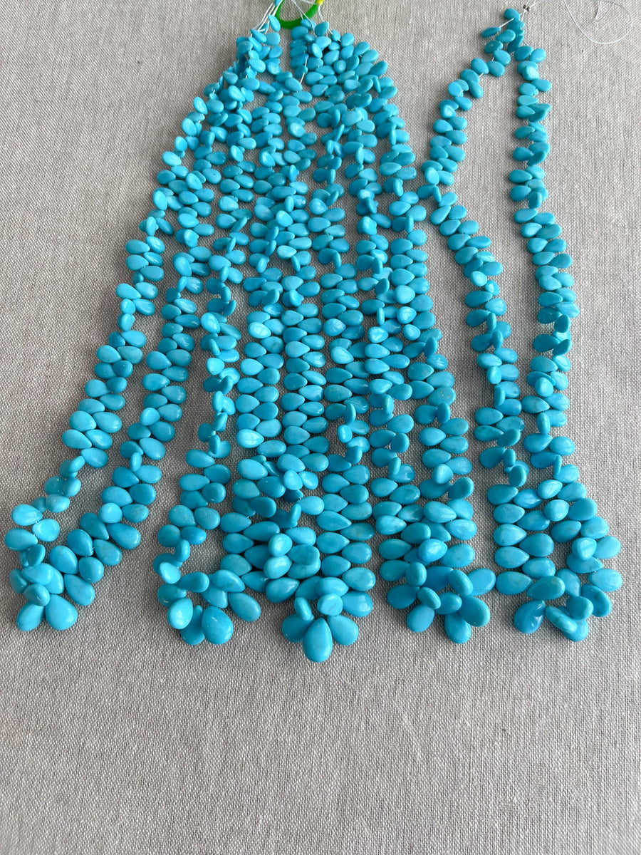 Smooth almond-shaped Sleeping Beauty turquoise beads showing natural Arizona turquoise color and polished surfaces. 4 strands