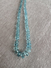 Close-up of AAA Aquamarine faceted rondelle beads showing transparent blue gemstones, excellent clarity, and sparkling hand-cut facets.