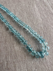 Close-up of AAA Aquamarine faceted rondelle beads showing transparent blue gemstones, excellent clarity, and sparkling hand-cut facets.
