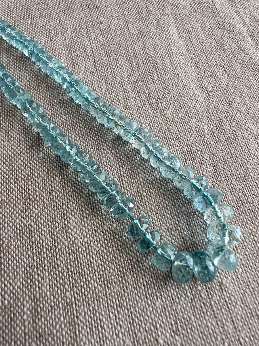 Close-up of AAA Aquamarine faceted rondelle beads showing transparent blue gemstones, excellent clarity, and sparkling hand-cut facets.