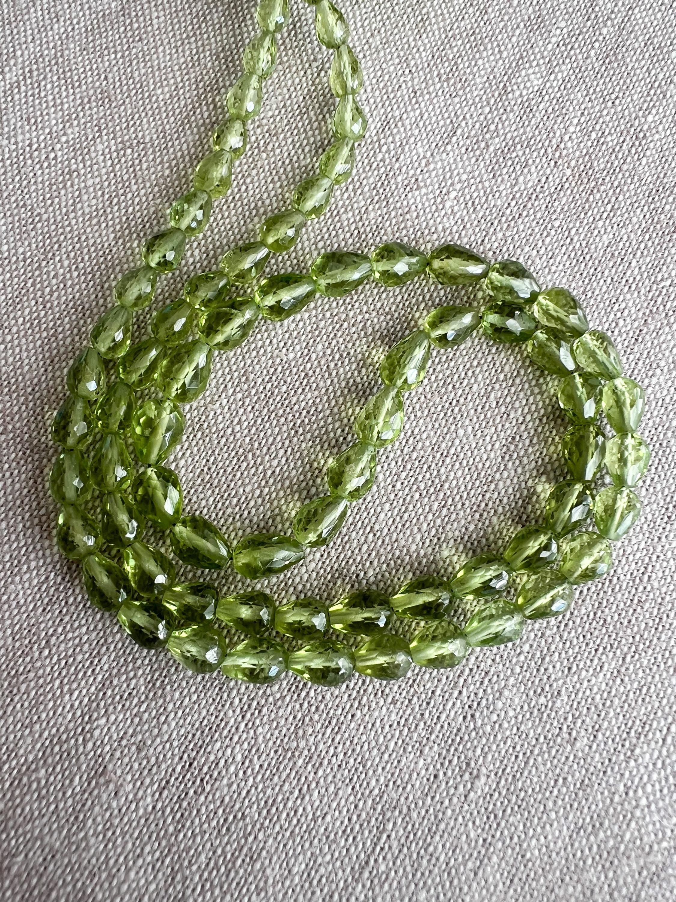 AAA+ natural Peridot faceted teardrop beads in vibrant green, straight center drilled, graduated from 4x5mm to 5x6mm.