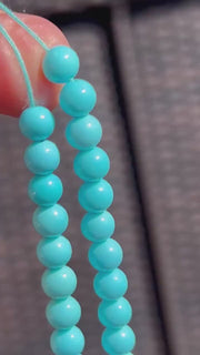Close-up of 6mm Sleeping Beauty Turquoise round beads showing classic robin's egg blue color and smooth polished surfaces.