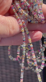 16-inch strand of natural unheated Sapphire faceted rondelle beads in assorted colors, graduated from 2.5mm to 4mm. multiple strands in natural sunlight