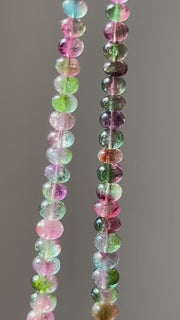 AAA-grade natural bi-color tourmaline smooth rondelle gemstone beads, graduated from 5.5mm to 11mm, featuring beautiful natural color variations for jewelry making. clear detail close up video of bead color