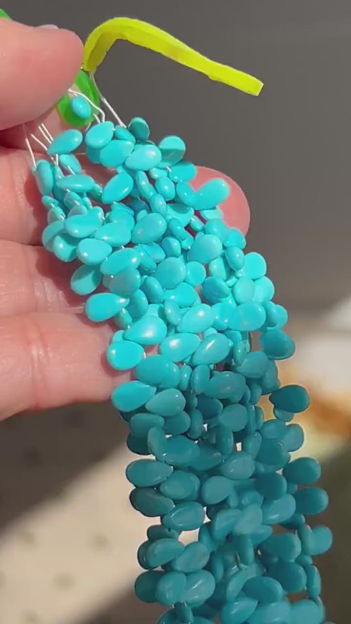 Smooth almond-shaped Sleeping Beauty turquoise beads showing natural Arizona turquoise color and polished surfaces. video of multiple strands
