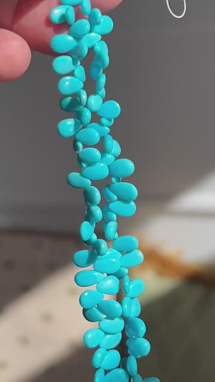 AAA-grade natural Sleeping Beauty turquoise smooth almond-shaped gemstones from Arizona, featuring classic robin's egg blue color and a polished finish.